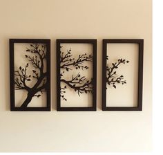 three metal wall art pieces with trees on them