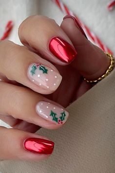 Short chrome red festive Christmas nails with two accent nude nails adorned with red and green holly nail art and white dots - Credit: Instagram@lindseysbeautylounge1 Red Christmas Nails With Mistletoe, French Tip December Nails, Popular Christmas Nails 2024, Short Gel X Christmas Nails, Simple Christmas Wreath Nails, Christmas Shellac Nails Winter, Red Holly Nails, Short Christmas Manicure, Hard Gel Christmas Nails