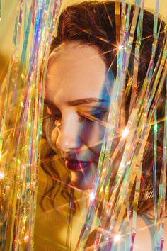 a woman with long hair is looking at her cell phone while surrounded by colorful streamers