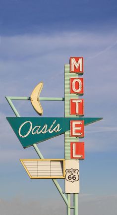 a motel sign with the word oasis on it's side and a banana hanging from the top