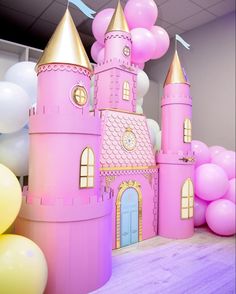 a pink castle with balloons in the background