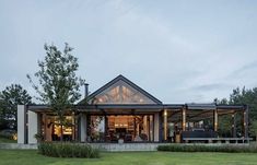 a house that is in the middle of a grassy area with lots of trees around it