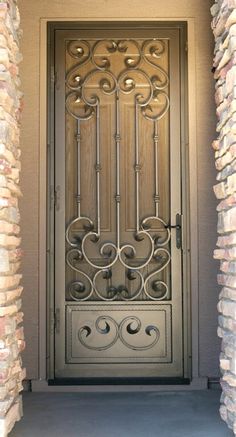 an ornate iron door is surrounded by stone pillars