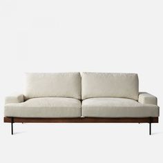 a white couch sitting on top of a wooden frame