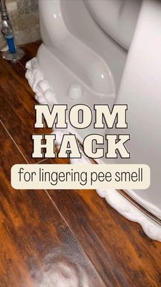 a white toilet sitting on top of a wooden floor next to a bathroom sink with the words mom hack for ingering pee smell