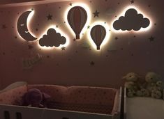 a baby's nursery room with hot air balloons and stars on the wall above it