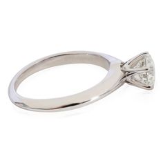 a white gold ring with a single diamond in the center and an arrow on the side