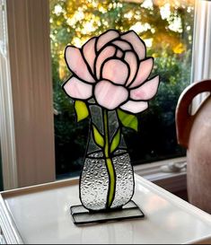 a stained glass flower in a vase on a table