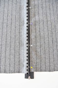 an aerial view of a piece of fabric with holes in the middle and pins on it