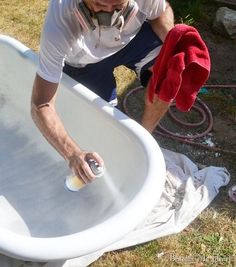 a man is cleaning an old bathtub outside