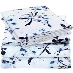 three sheets with blue and white flowers on them are folded up in front of each other