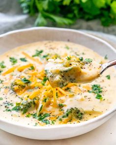 a white bowl filled with broccoli cheese soup