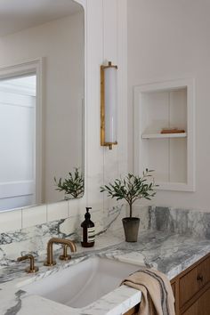 a bathroom with marble counter tops and wooden cabinets, along with a white porcelain sink