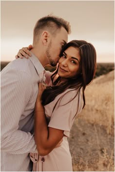 a man and woman are kissing in the desert