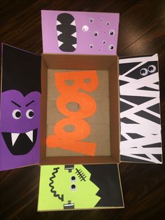 three cardboard boxes decorated with halloween decorations and the word boo spelled out in bold letters