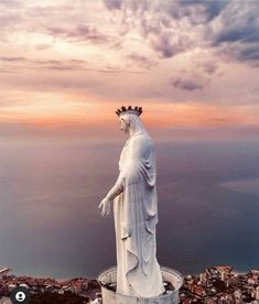 there is a statue with a crown on top of it in front of the ocean