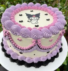 a cake decorated with purple and black icing sitting on top of a white plate