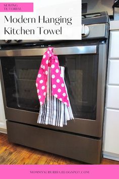 modern hanging kitchen towel hanger on the front of an oven with pink and white polka dots