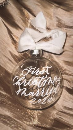 a glass ornament with a white bow on it