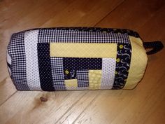 a black and white patchwork bag sitting on top of a wooden floor