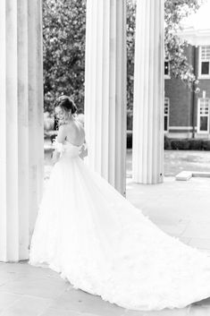 bride stands near pillar at Belk Chapel with dress pulled out behind her | Charlotte wedding day at Belk Chapel and the Palmer Building with North Carolina wedding photographer Kevyn Dixon Photography.