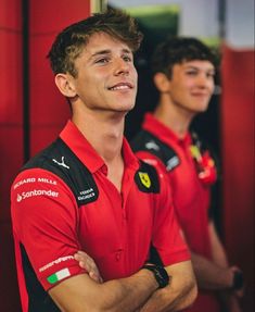 two men in red shirts standing next to each other