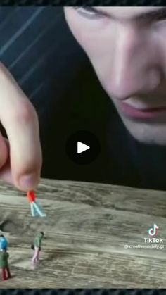 a man is playing with small toy people