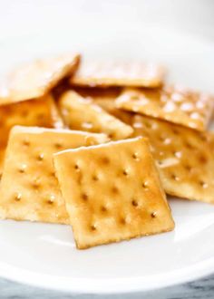 some crackers on a white plate sitting on a table