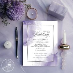 wedding stationery with candles and flowers on a purple table cloth next to a candle