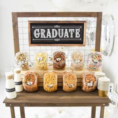 a wooden table topped with lots of different types of cereals and candy bar items