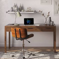 a desk with a laptop computer on top of it next to a chair and lamp