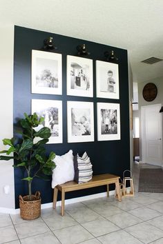 a living room with pictures on the wall and a wooden bench in front of it