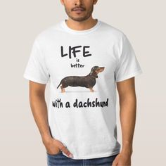 a man wearing a white t - shirt with a black and brown dachshund on it