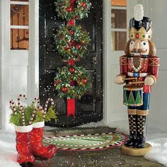 a nutcracker is standing in front of a christmas tree and potted plant