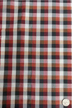 a red and black checkered fabric with a button on it