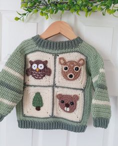 a knitted sweater hanging on a door with an owl, bear and pine tree motif