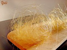 a close up of a piece of bread on a cutting board covered in yellow hair