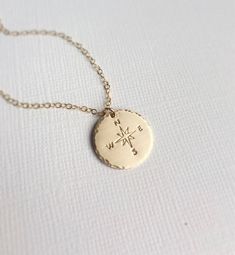 "14k gold fill Compass Necklace. ➳All metal is genuine 14k gold fill - chain, clasp and pendant. ➳Hand stamped Compass Symbol with hammered edge and brushed finish ➳Closure is a 14k gold fill lobster clasp with crystal pearl beads. \"Not all who wander are lost.\" \"Choose your own adventure.\" \"She believed she could, so she did.\" \"Enjoy the journey, wherever it may take you.\" \"Go confidently in the direction of your dreams.\" Whether graduating and moving on or traveling to a far away lan Stamped 14k Gold Rose Gold Jewelry, Gold Stamped Pendant Charm Necklace, Engraved Round Pendant Jewelry For Everyday Use, Personalized Gold Stamped Jewelry, Everyday Engraved Round Pendant Jewelry, Personalized Stamped Gold Jewelry, 14k Gold Stamped Jewelry As Gift, Gold Brass Jewelry With Compass Design, Everyday Gold Stamped Jewelry