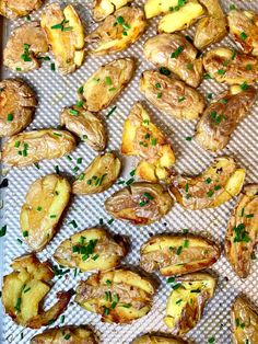 cooked potatoes on a baking sheet with parsley sprinkled around them, ready to be baked