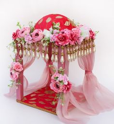 a pink canopy bed with flowers on it