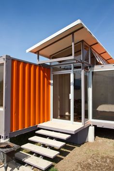 an orange shipping container with stairs leading up to it