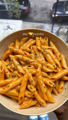 a person holding a bowl full of pasta