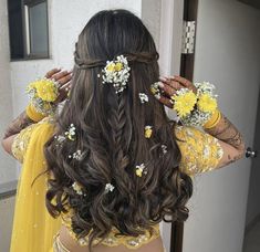 a woman with long hair and flowers in her hair is looking at the camera while wearing a yellow dress