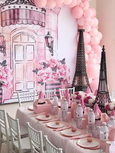 a table set up with pink and white decorations for a paris themed birthday or baby shower