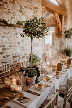 the table is set with candles, plates and vases for an elegant wedding reception