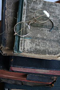 an old book with glasses resting on it