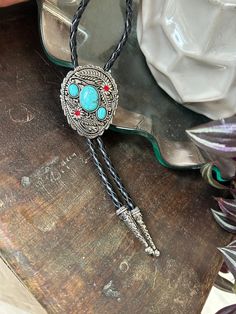 This awesome bolo tie has a southwestern design and faux turquoise pieces. The cord is genuine leather.   Measurements/Sizing   Total length of leather is approx. 40 inches 2 3/8 x 2 7/8 in pendant Bohemian Hand Tooled Jewelry For Rodeo, Western Bolo Ties With Adjustable Length, Vintage Bolo Ties With Adjustable Length For Rodeo, Adjustable Vintage Bolo Ties For Ranch, Turquoise Concho Jewelry For Rodeo, Concho Lariat Bolo Tie For Western-themed Events, Concho Jewelry For Rodeo, Bohemian Concho Jewelry For Rodeo, Adjustable Western Bolo Tie With Concho