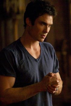 a man in a blue shirt holding his hands together