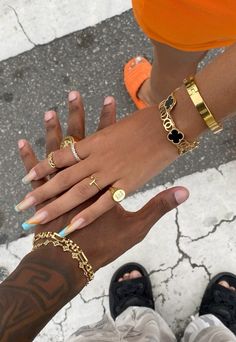 two people holding hands with different types of rings on their fingers and one wearing an orange shirt