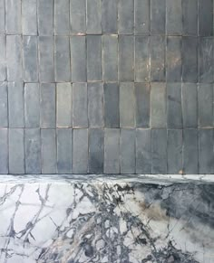 a black and white marble counter top next to a tiled wall